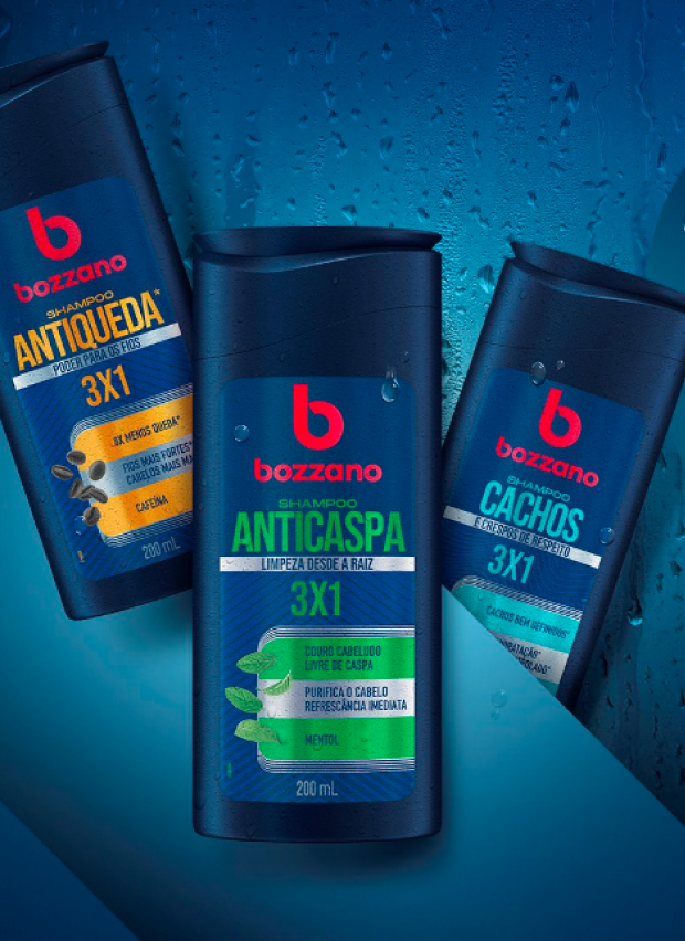 Imagem de divulgao dos novos shampoos e condicionadores Bozzano. Trs embalagens dos novos produtos esto posicionadas em um fundo azul-escuro ao lado do logo da marca e slogan do lanamento.